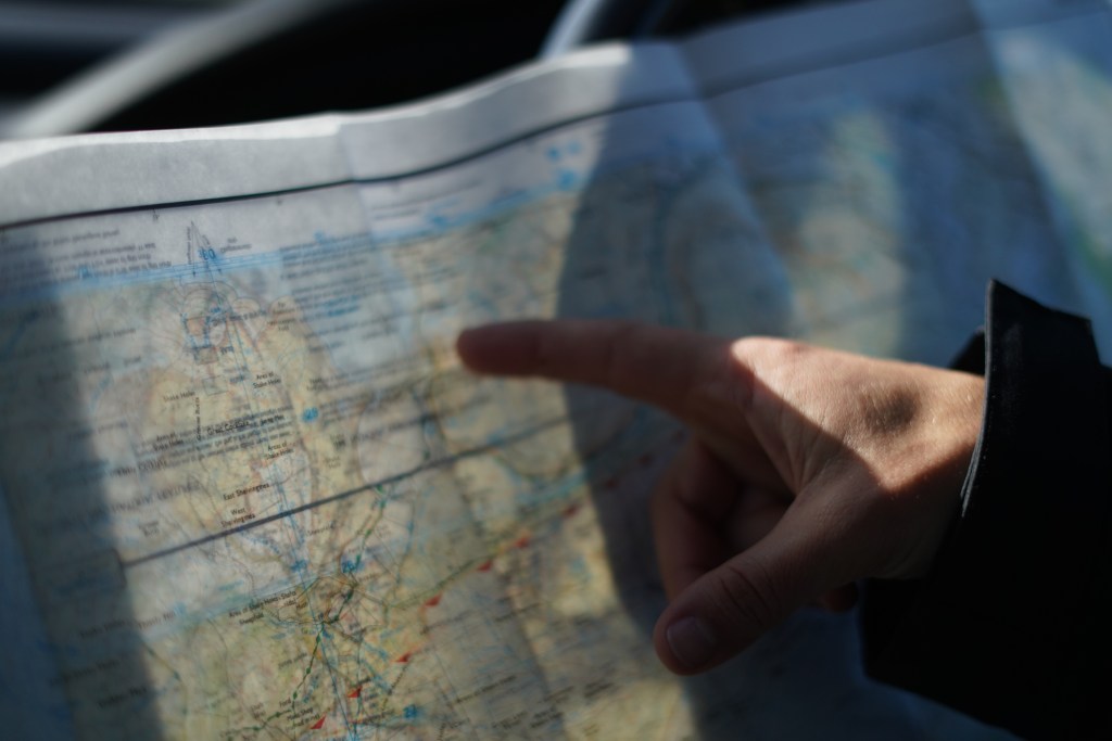 Image of a map with a finger pointing at it